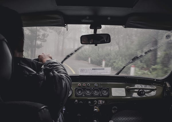 person-in-car-wearing-wet-jacket-driving-in-rain